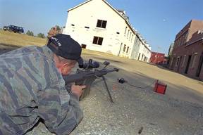 Image of Soldier firing a Rifle in an urban area.